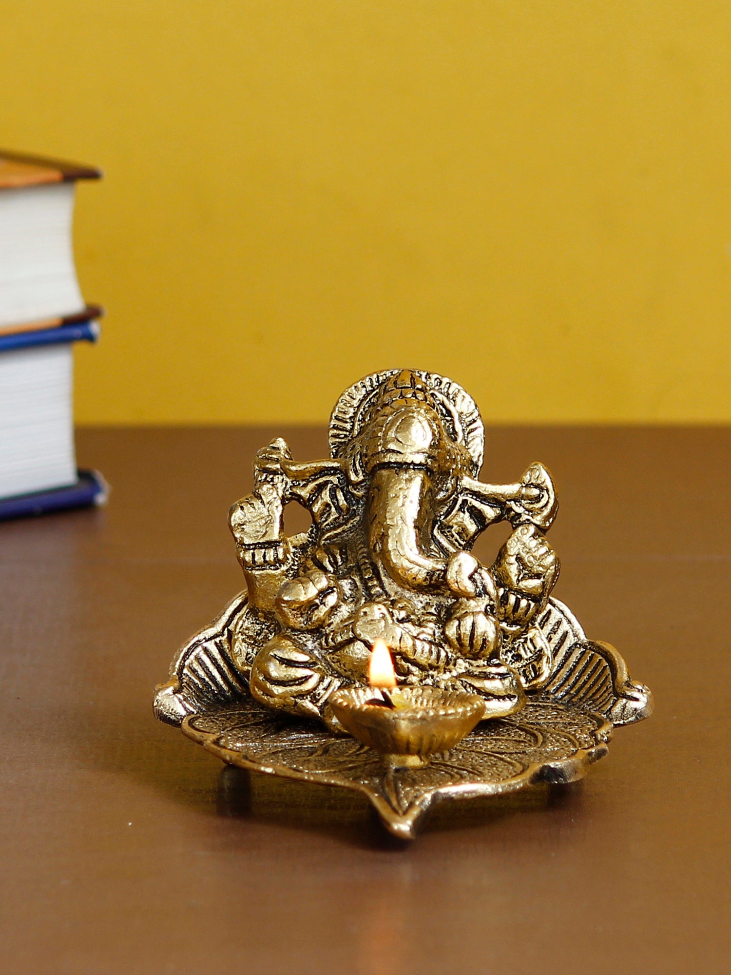 Golden Metal Handcrafted Lord Ganesha Idol with Diya on Leaf 1