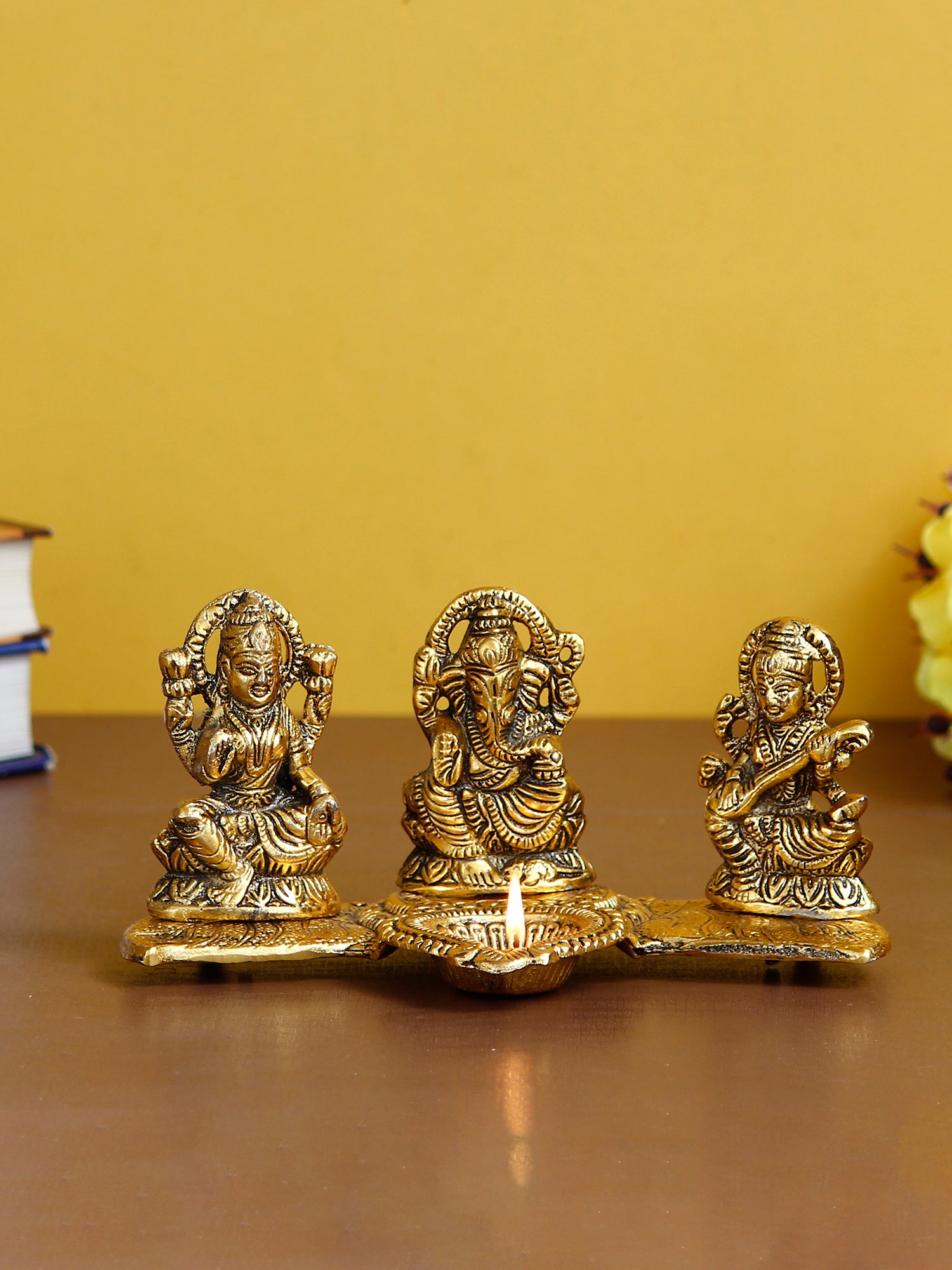 Gold Metal Handcrafted Laxmi Ganesha Saraswati Idols with Diya on Leaf Chowki 1