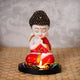 ecraftindia-praying-red-monk-buddha-with-wooden-base-fragranced-petals-and-tealight-1