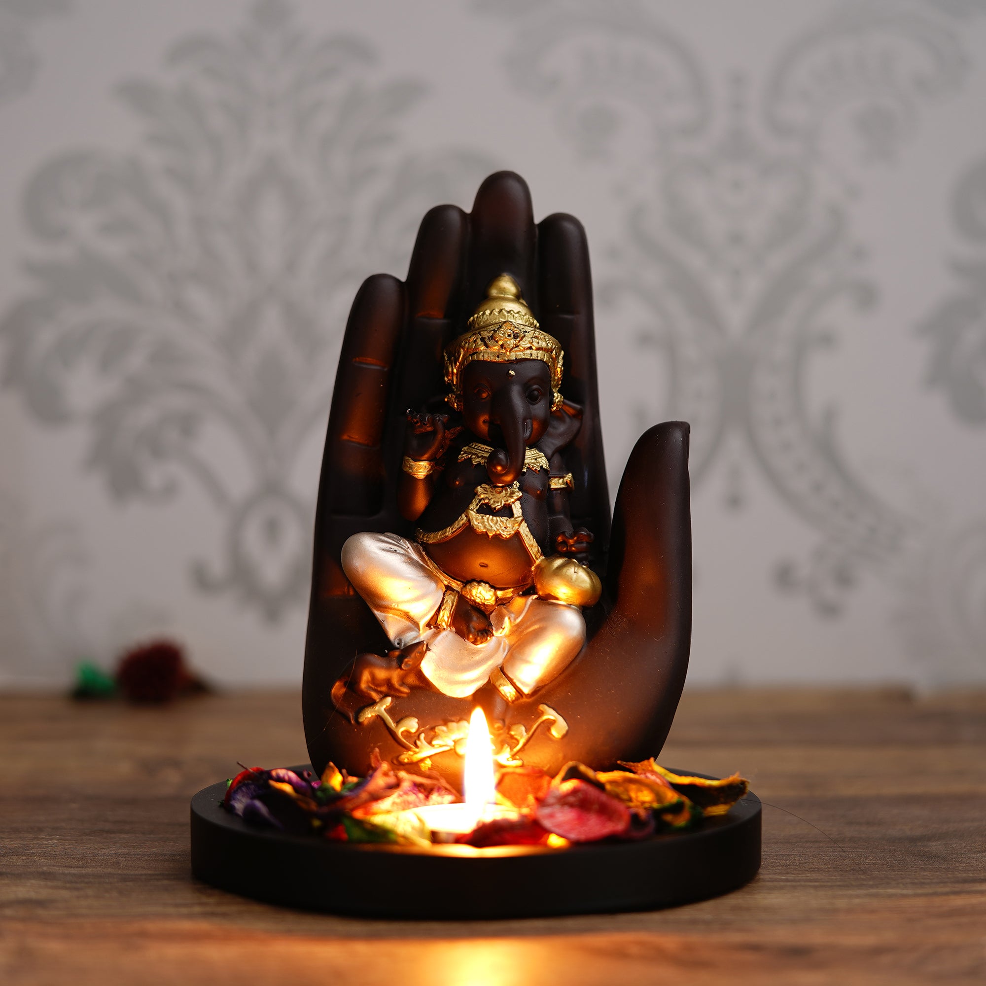 Golden and Black Handcrafted Palm Ganesha Idol on Wooden Base with Fragranced Petals Tealight Candle Holder 1