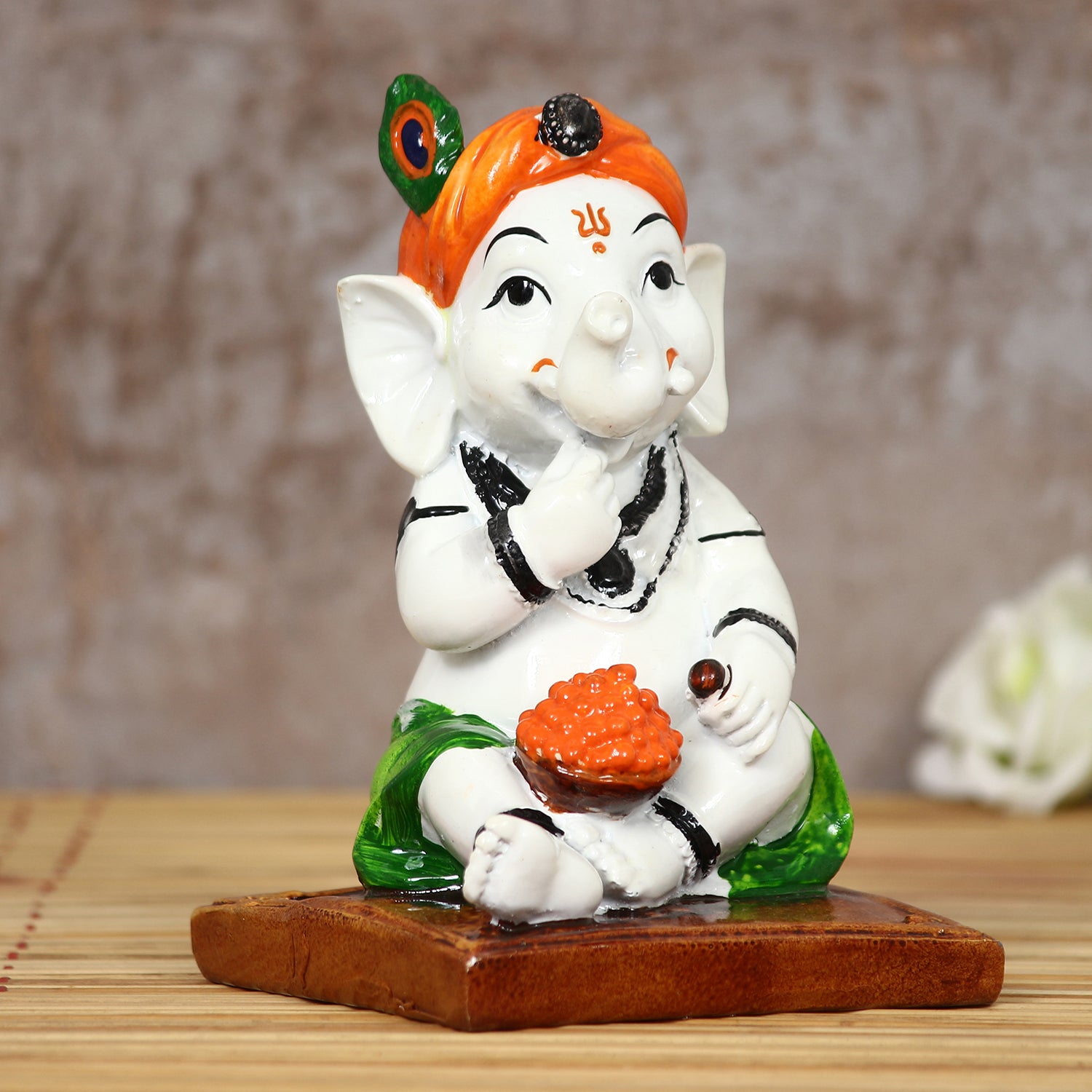 Decorative Polyresin Lord Ganesha Idol eating Ladoo in Lord Krishna Avatar (White, Orange, Green)