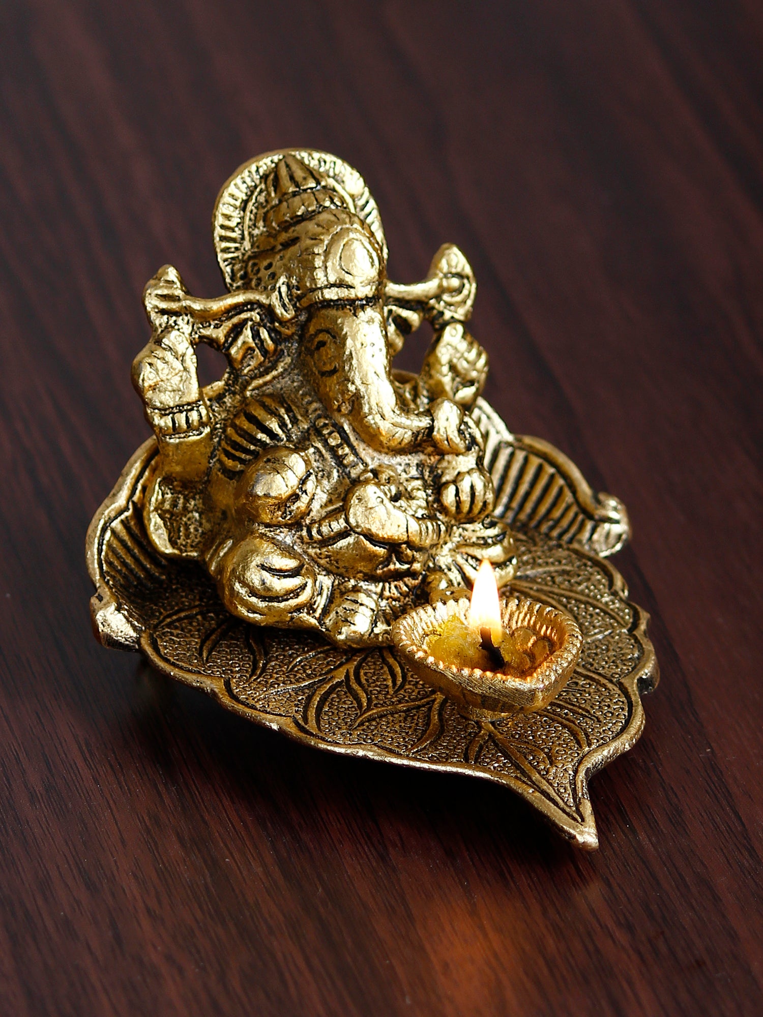 Golden Metal Handcrafted Lord Ganesha Idol with Diya on Leaf