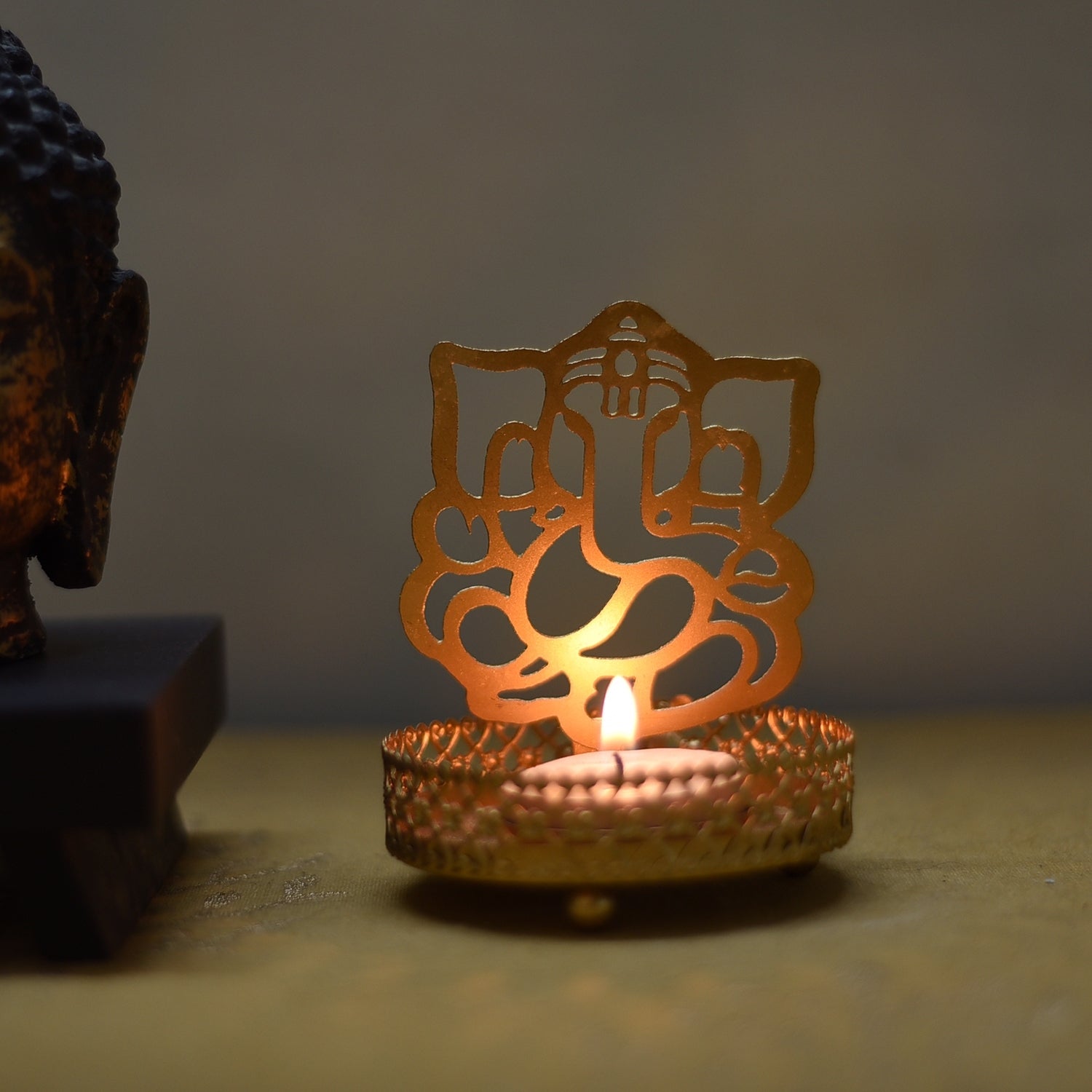 Metal Golden Lord Ganesha tea light candle holder that cast shadows 1