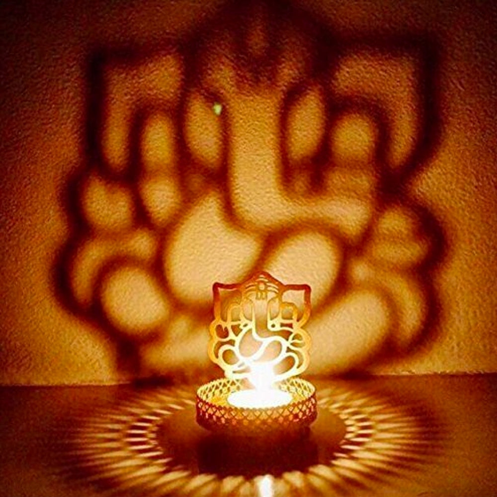 Metal Golden Lord Ganesha tea light candle holder that cast shadows