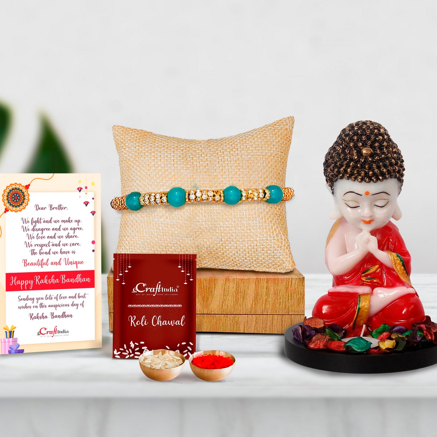 Designer Pearl Rakhi with Praying Red Monk Buddha with Wooden Base, Fragranced Petals and Tealight and Roli Chawal Pack, Best Wishes Greeting Card