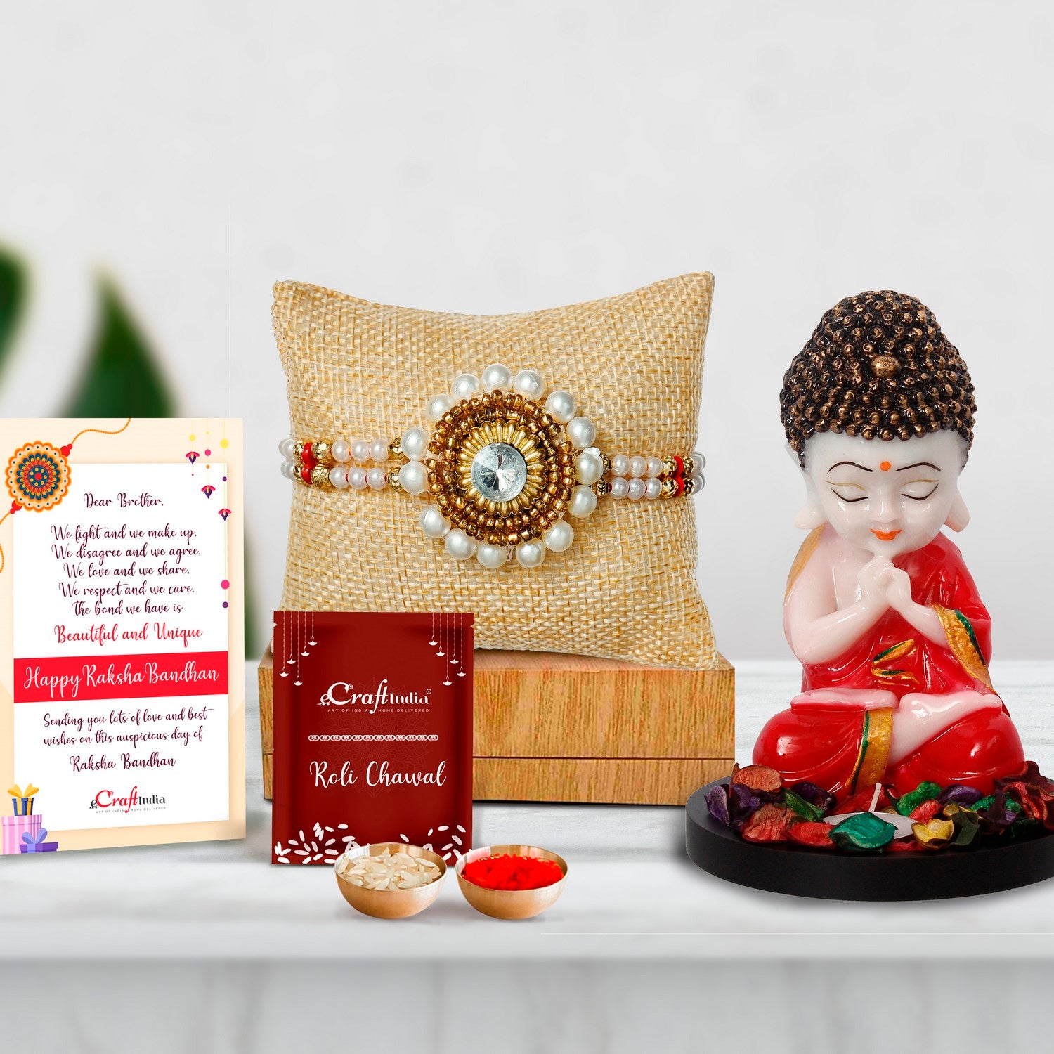 Designer Handcrafted Stone Pearl Rakhi with Praying Red Monk Buddha with Wooden Base, Fragranced Petals and Tealight and Roli Chawal Pack, Best Wishes Greeting Card