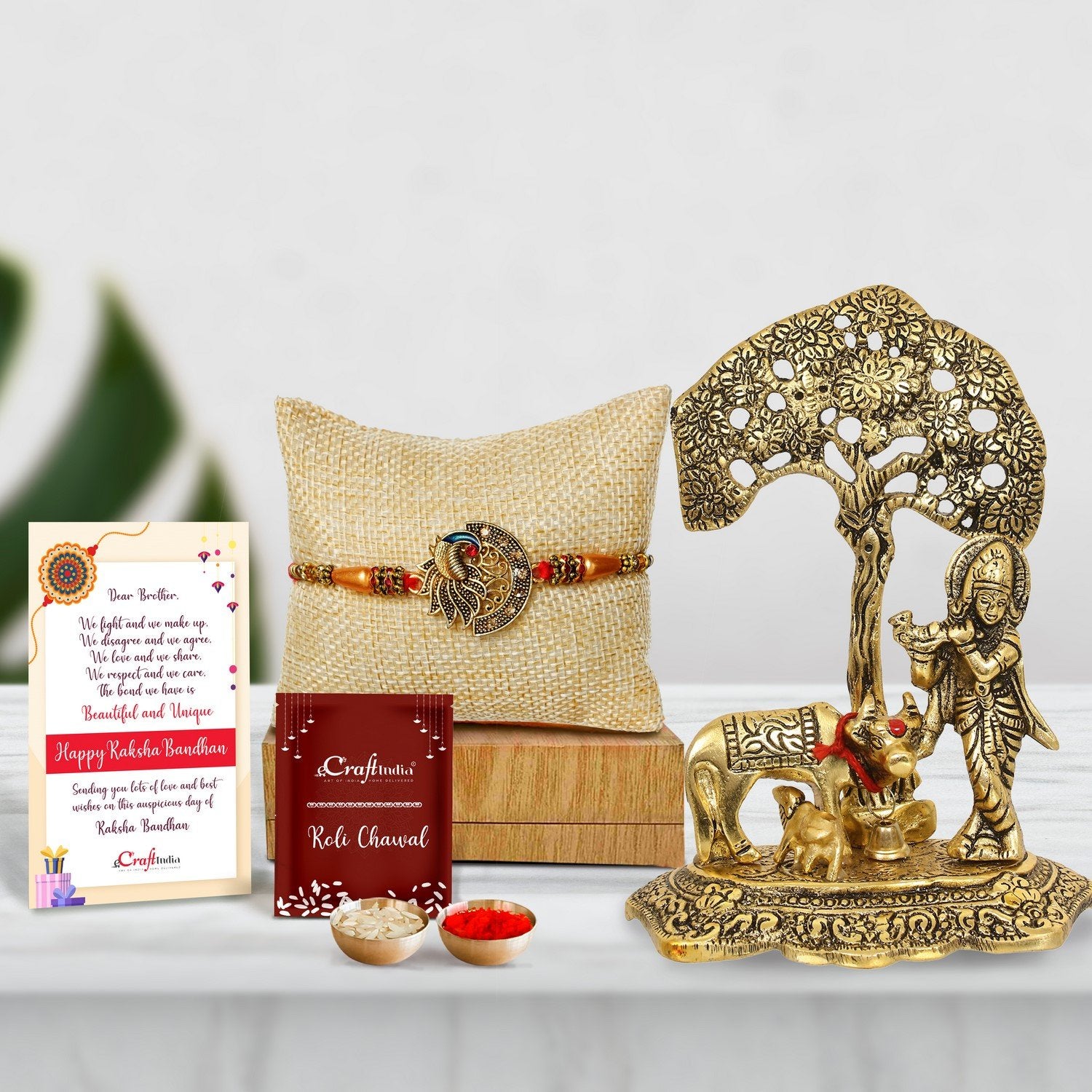 Designer Peacock Rakhi with Lord Krishna playing Flute under Tree with Golden Cow and Calf Showpiece and Roli Chawal Pack, Best Wishes Greeting Card