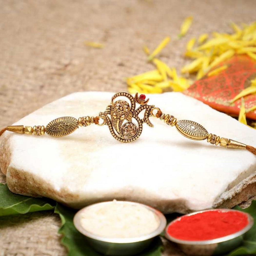 eCraftIndia Golden Beads, Diamonds Om Symbol Religious Designer Rakhi with Roli Chawal Pack
