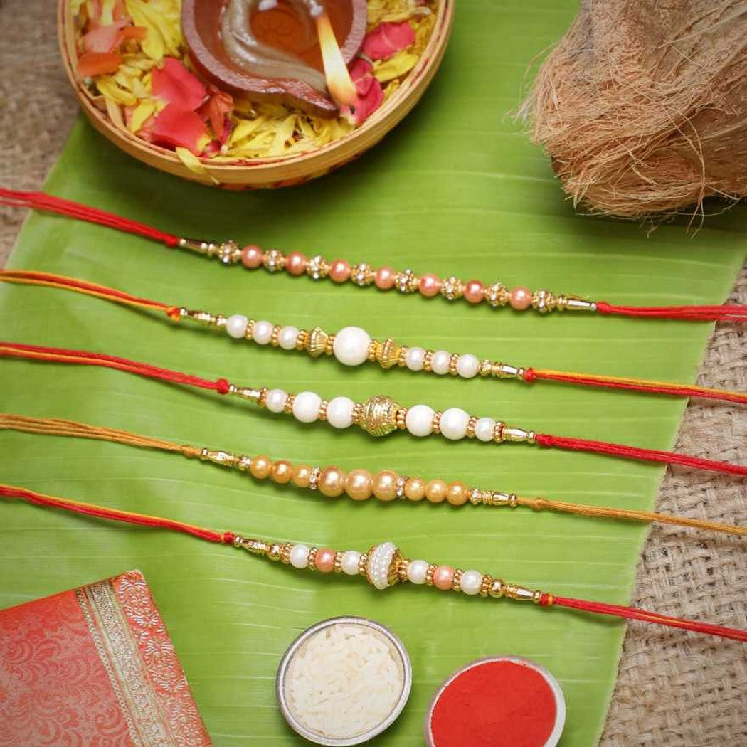 eCraftIndia Set of 5 White & Golden Pearls Rakhis with Roli Chawal Pack