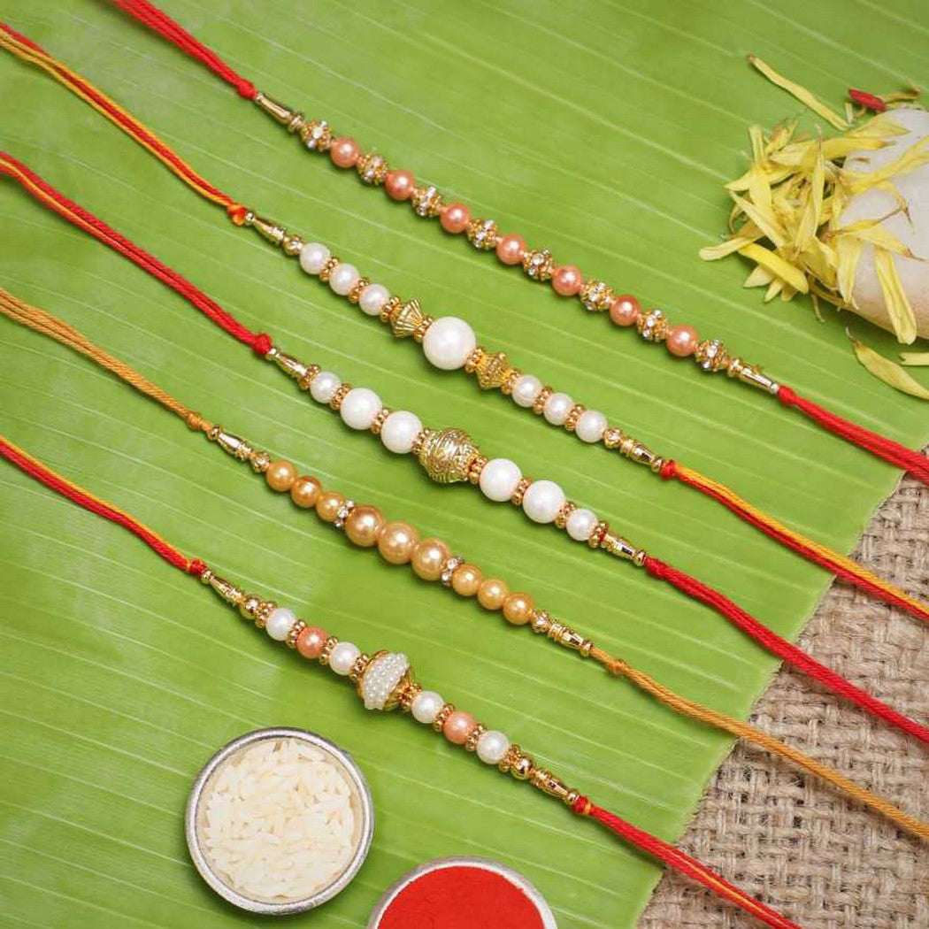 eCraftIndia Set of 5 White & Golden Pearls Rakhis with Roli Chawal Pack 1