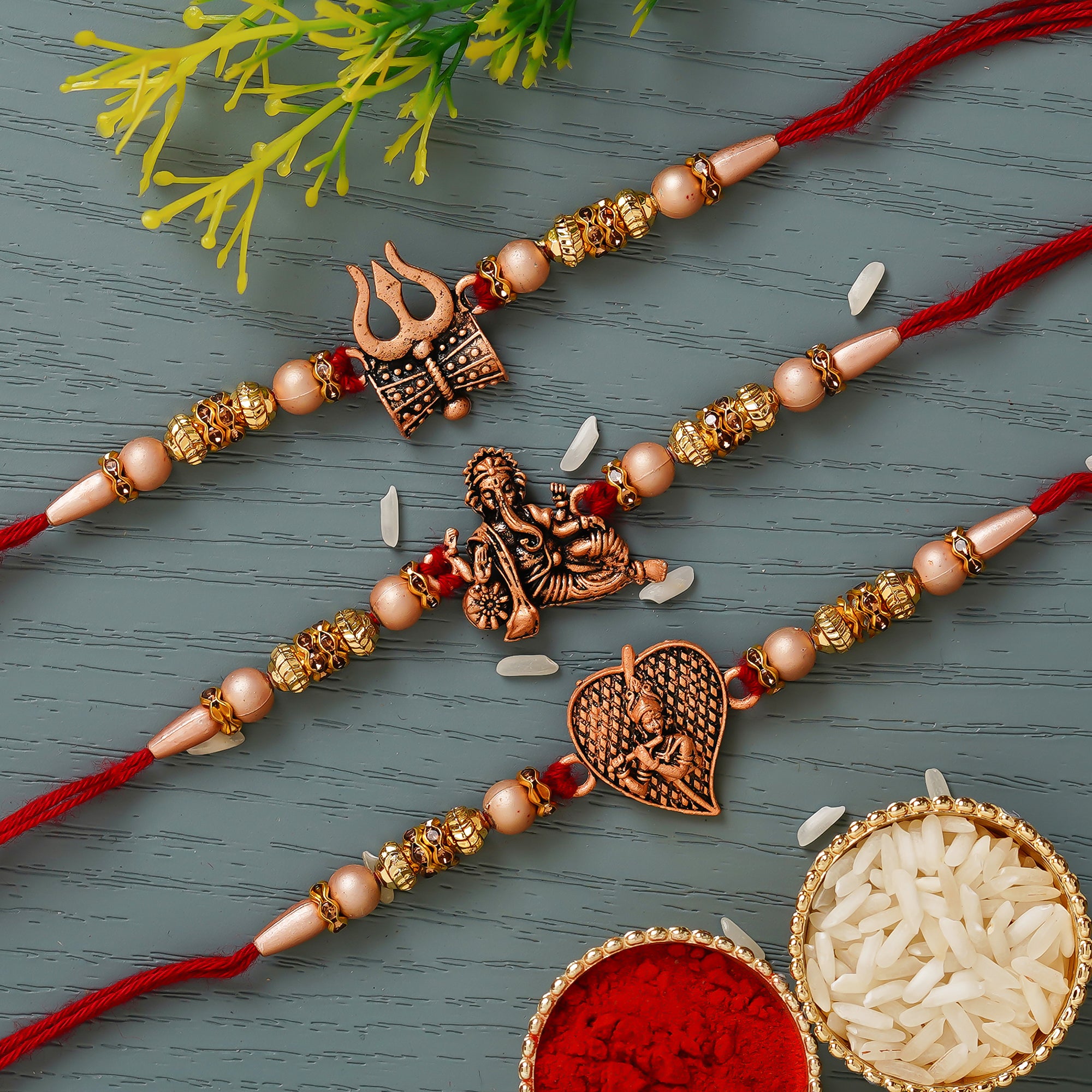 Red & Golden Set of 3 Trishul with Damru, Lord Ganesha, & Lord Krishna Playing Flute Religious Rakhis with Roli Chawal Pack