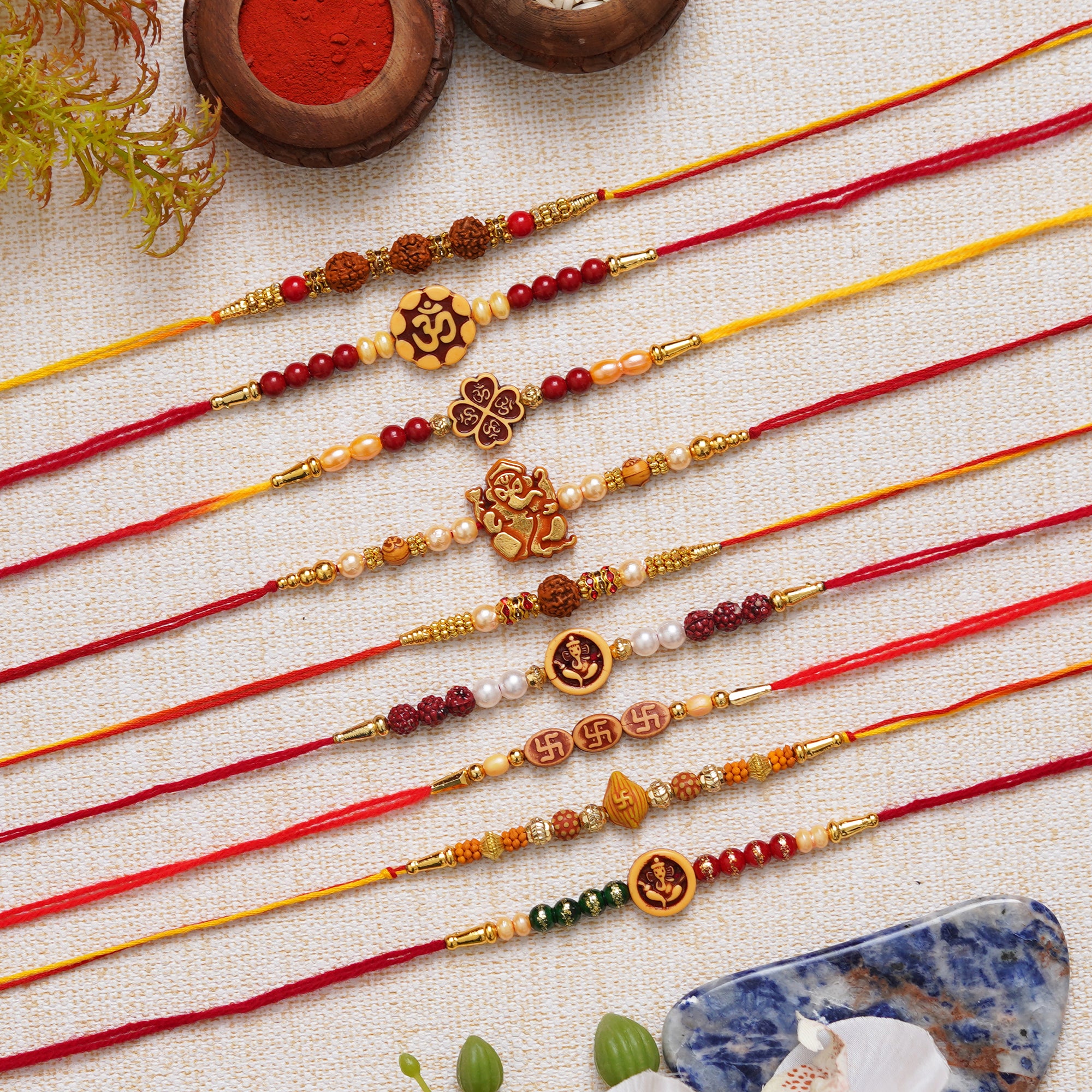 eCraftIndia Multicolor Set of 9 Om, Ganesha, Swastik, Rudraksha, Pearls Religious Designer Rakhis with Roli Chawal Pack