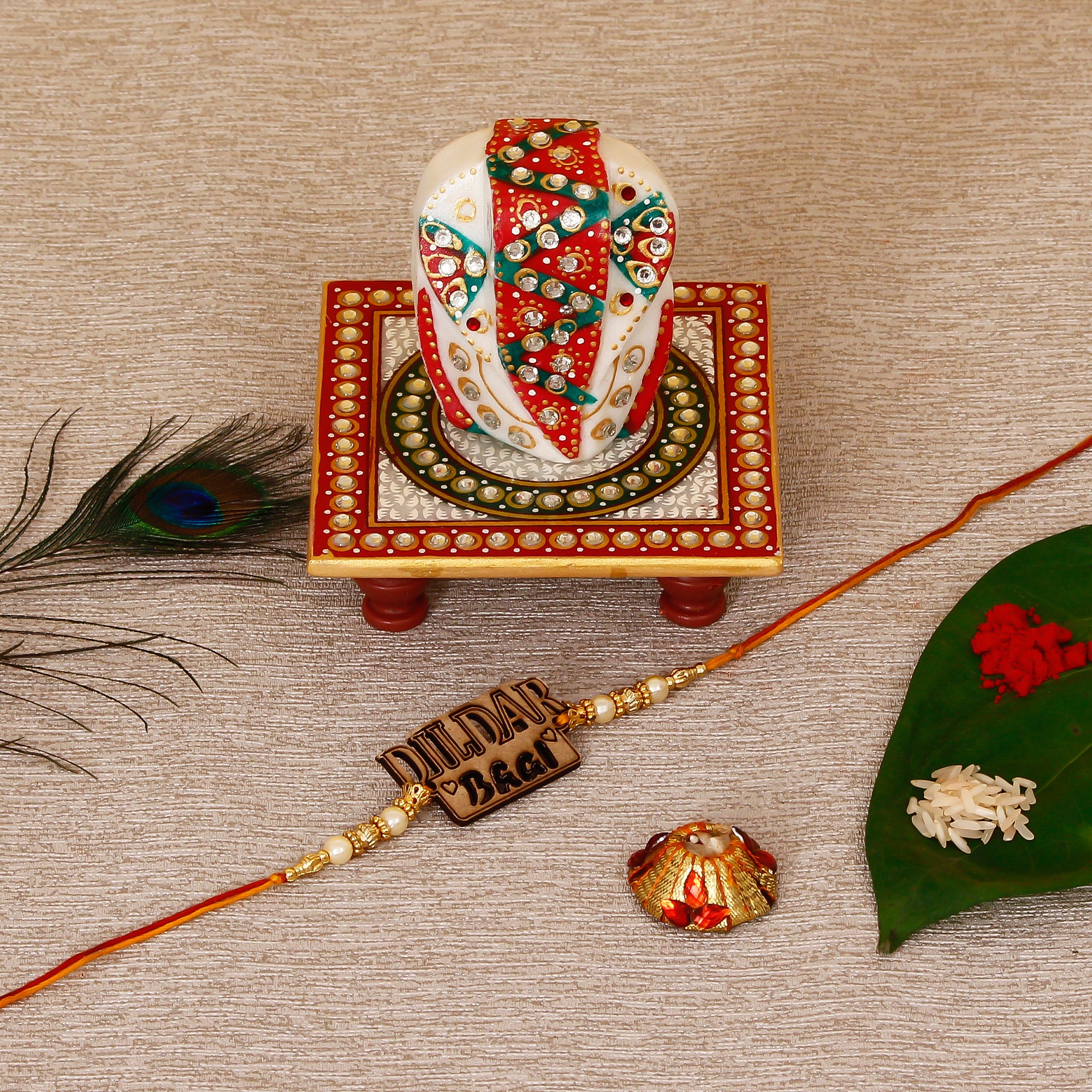 Designer Wooden Dildar Bhai Rakhi with Lord Ganesha on Kundan Studded Marble Chowki and Roli Tikka Matki