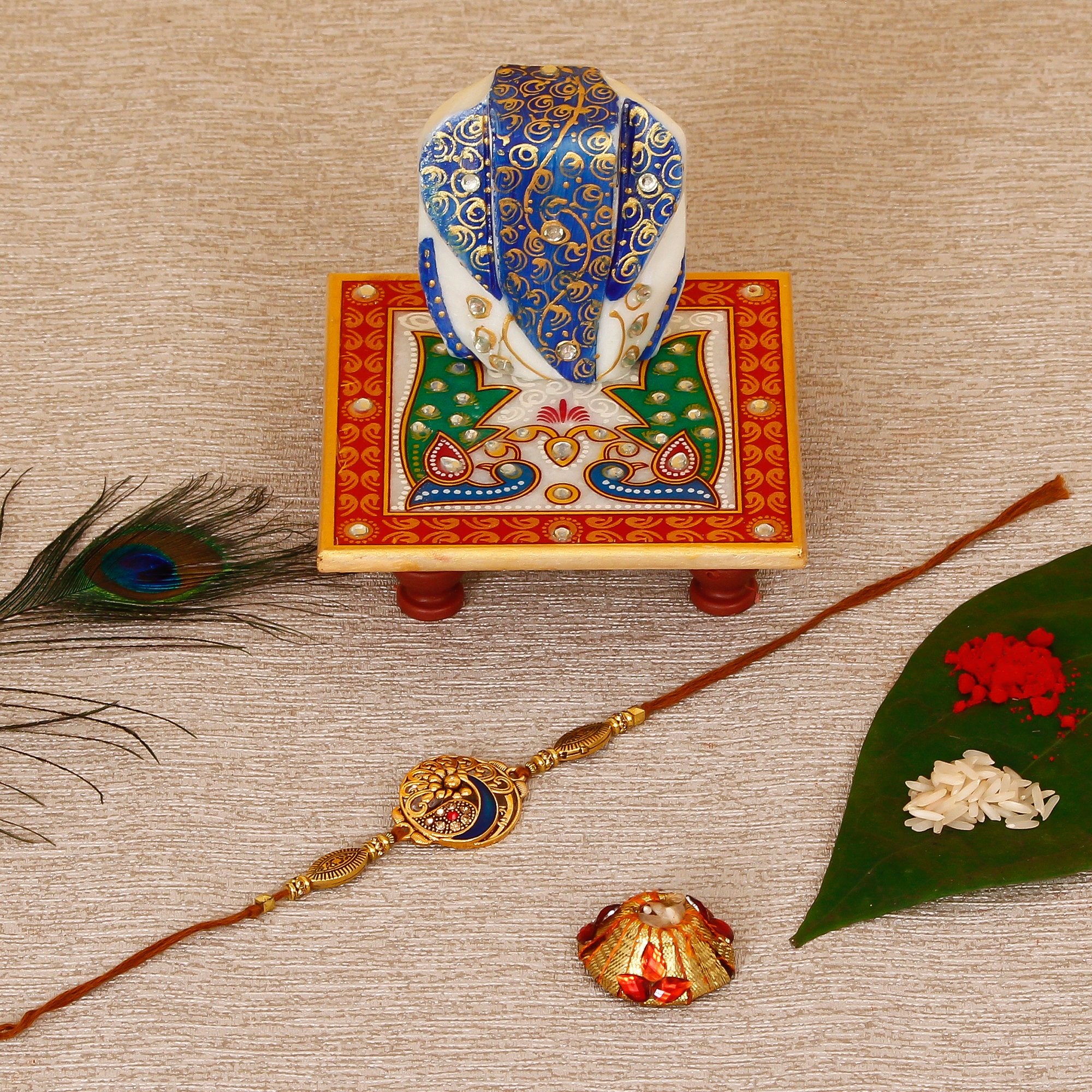 Designer Peacock Rakhi with Lord Ganesha on Marble Chowki and Roli Tikka Matki