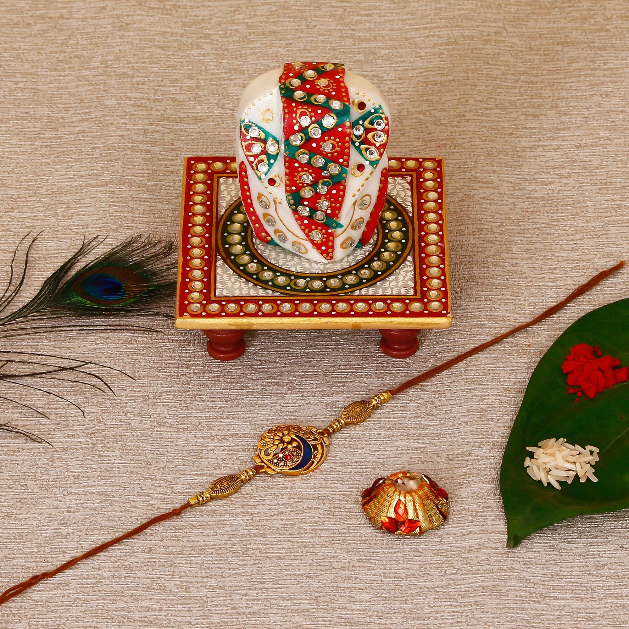 Designer Peacock Rakhi with Lord Ganesha on Kundan Studded Marble Chowki and Roli Tikka Matki