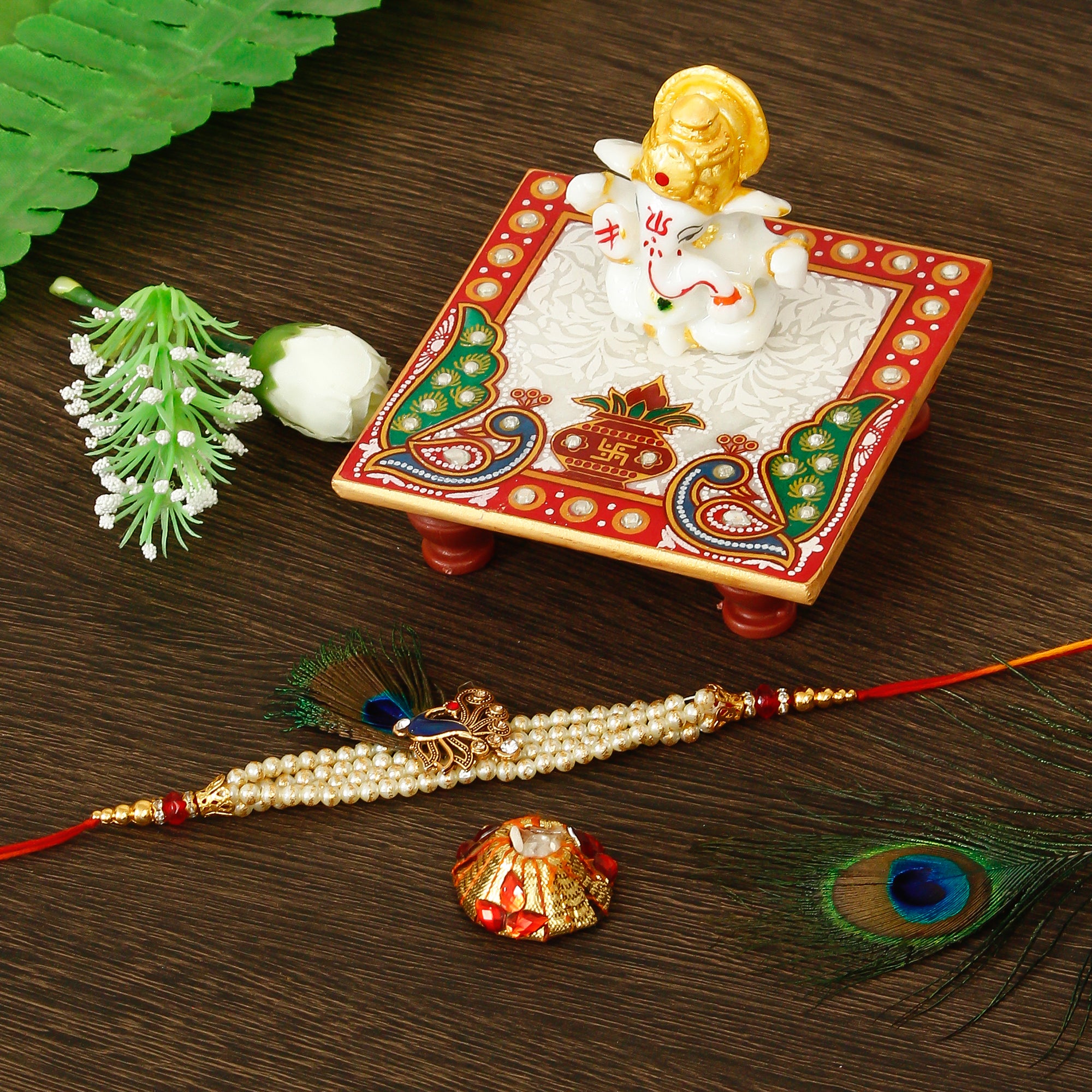 Designer Pearl Morpankh Rakhi with Lord Ganesha Marble Chowki and Roli Tikka Matki