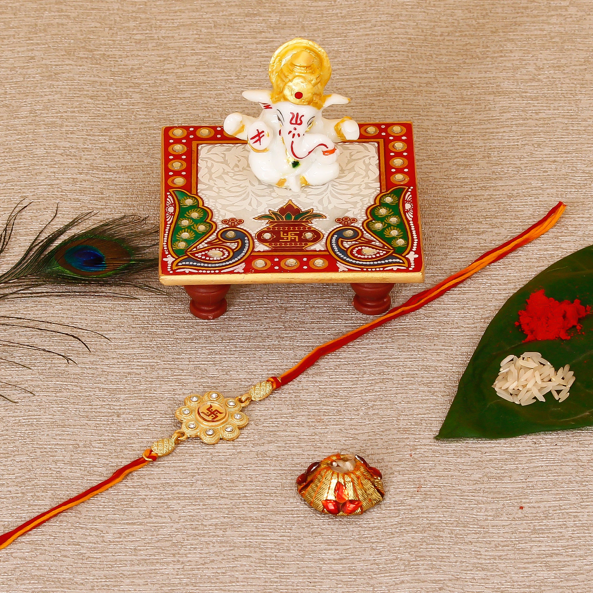 Designer Religious Swastik Rakhi with Lord Ganesha Marble Chowki and Roli Tikka Matki