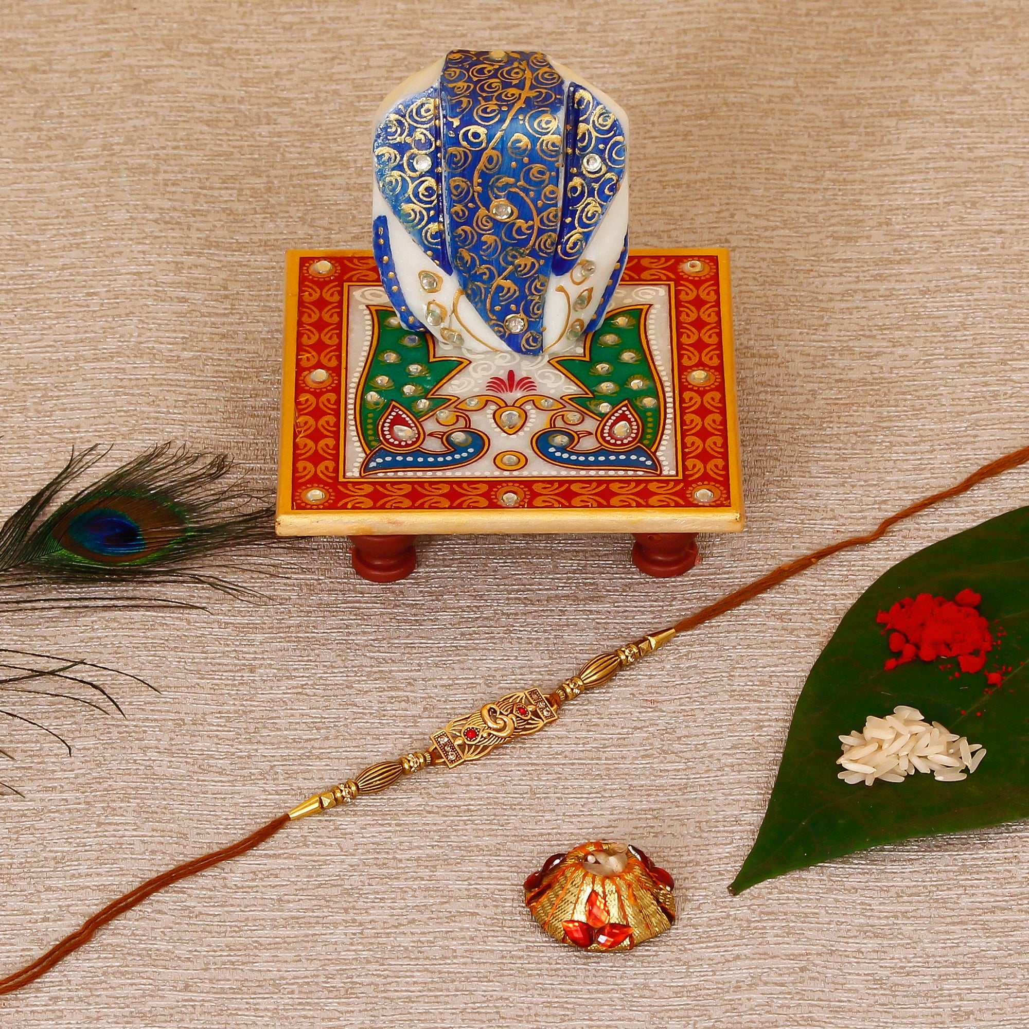Designer Religious Rakhi with Lord Ganesha on Marble Chowki and Roli Tikka Matki