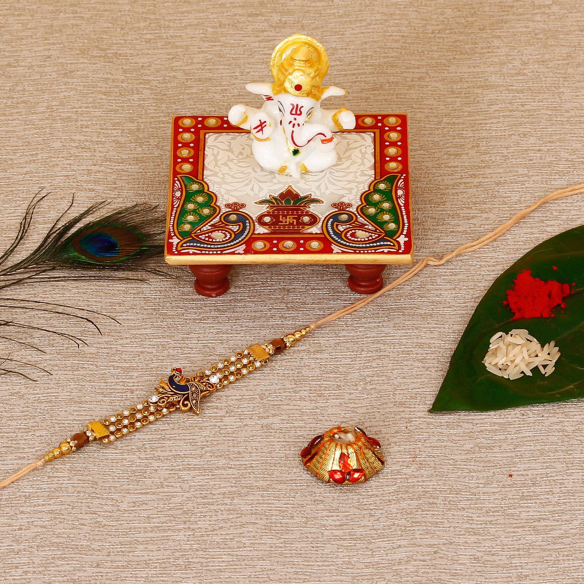 Designer Peacock Rakhi with Lord Ganesha Marble Chowki and Roli Tikka Matki