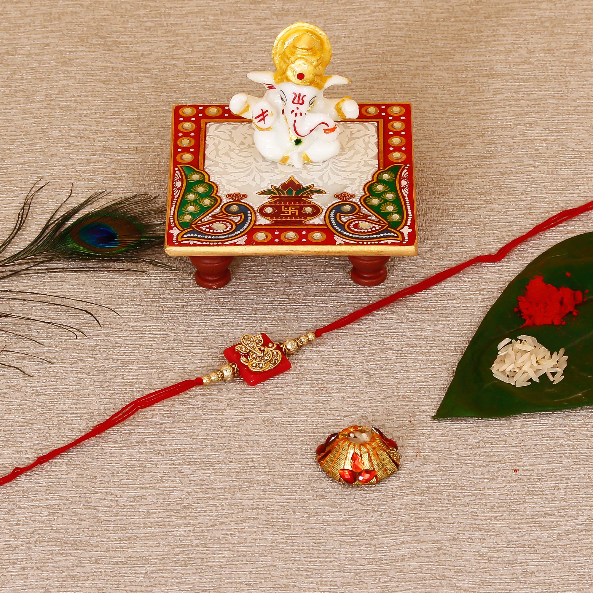Designer Religious Ganesha Rakhi with Lord Ganesha Marble Chowki and Roli Tikka Matki