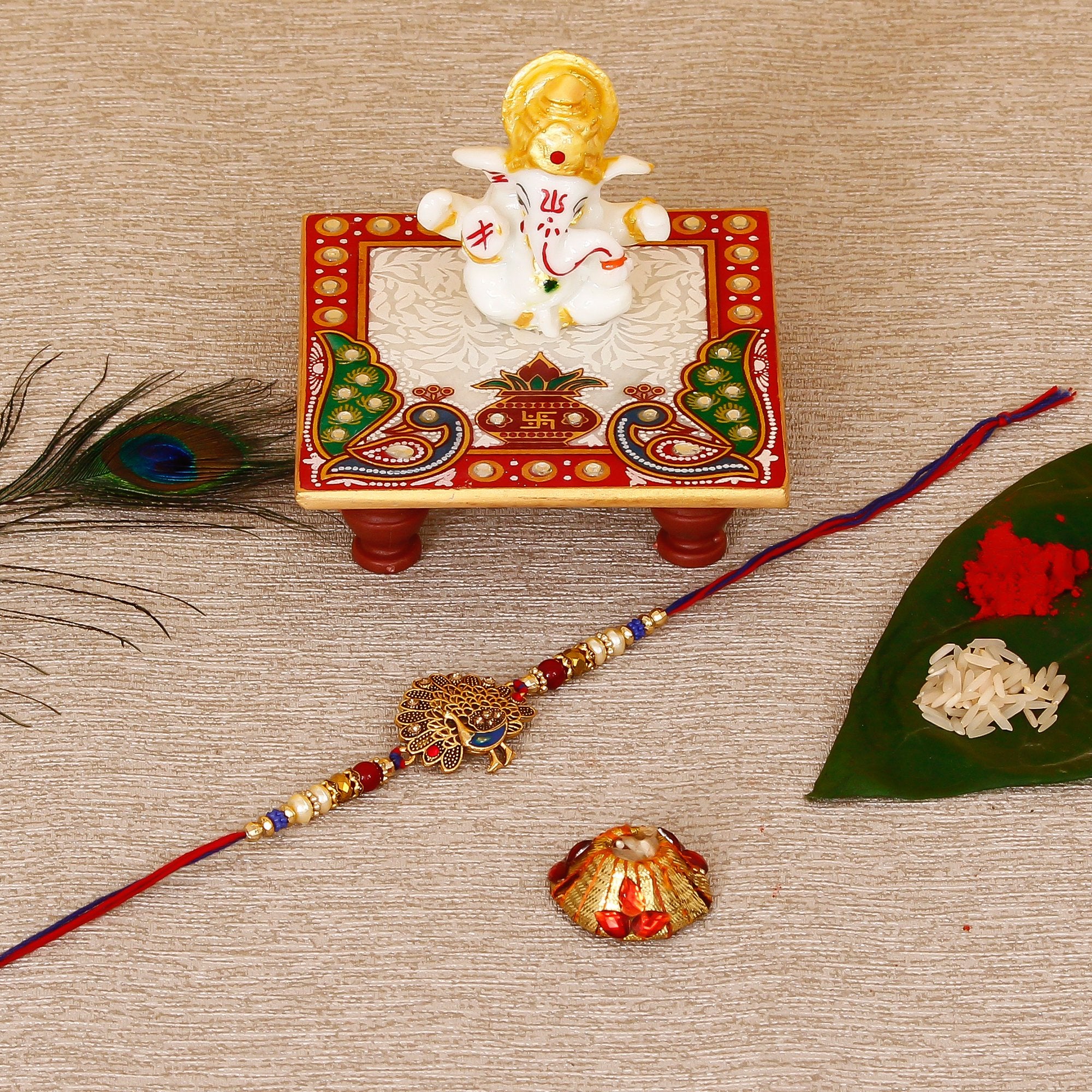 Designer Dancing Peacock Rakhi with Lord Ganesha Marble Chowki and Roli Tikka Matki