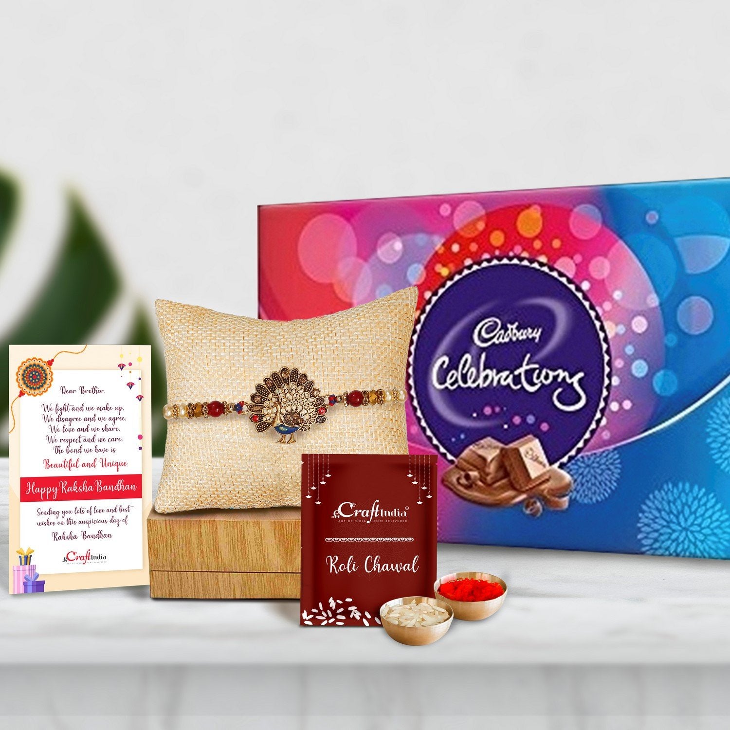 Designer Dancing Peacock Rakhi with Cadbury Celebrations Gift Pack of 7 Assorted Chocolates and Roli Chawal Pack, Best Wishes Greeting Card