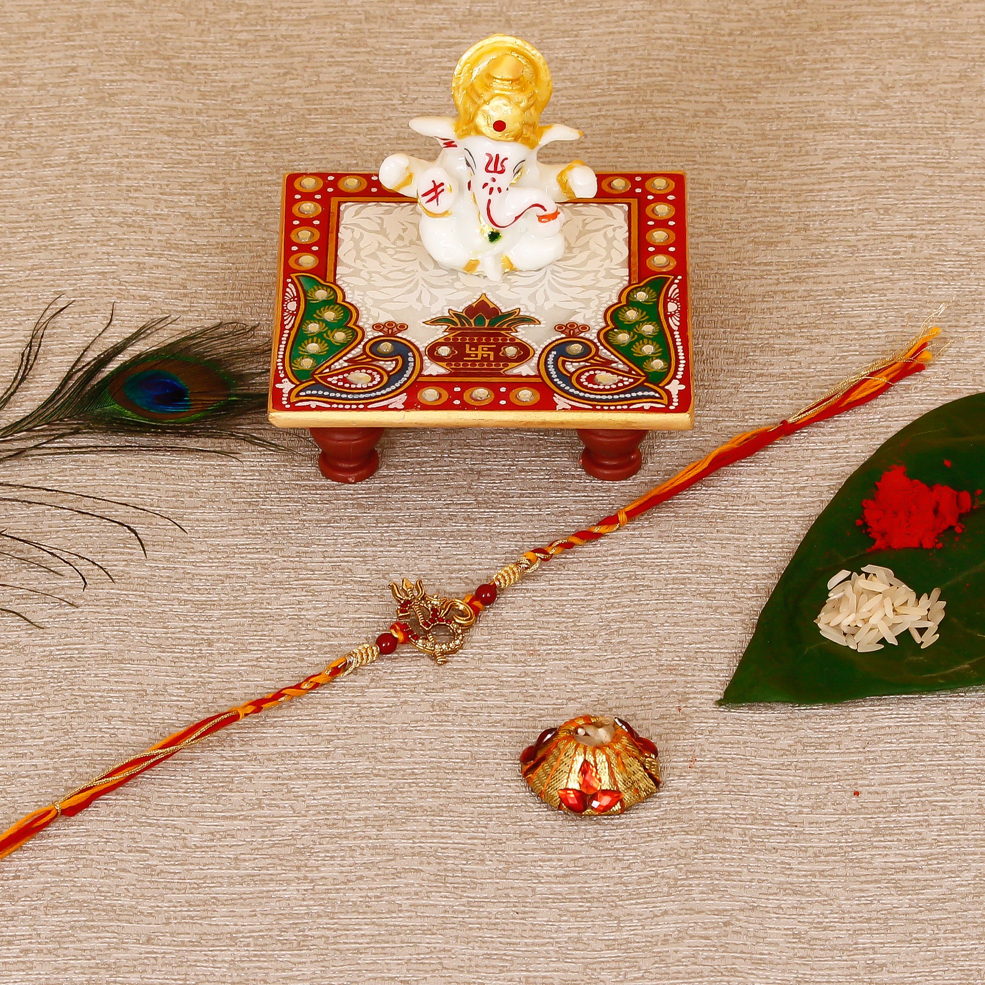 Designer Religious OM Rakhi with Lord Ganesha Marble Chowki and Roli Tikka Matki