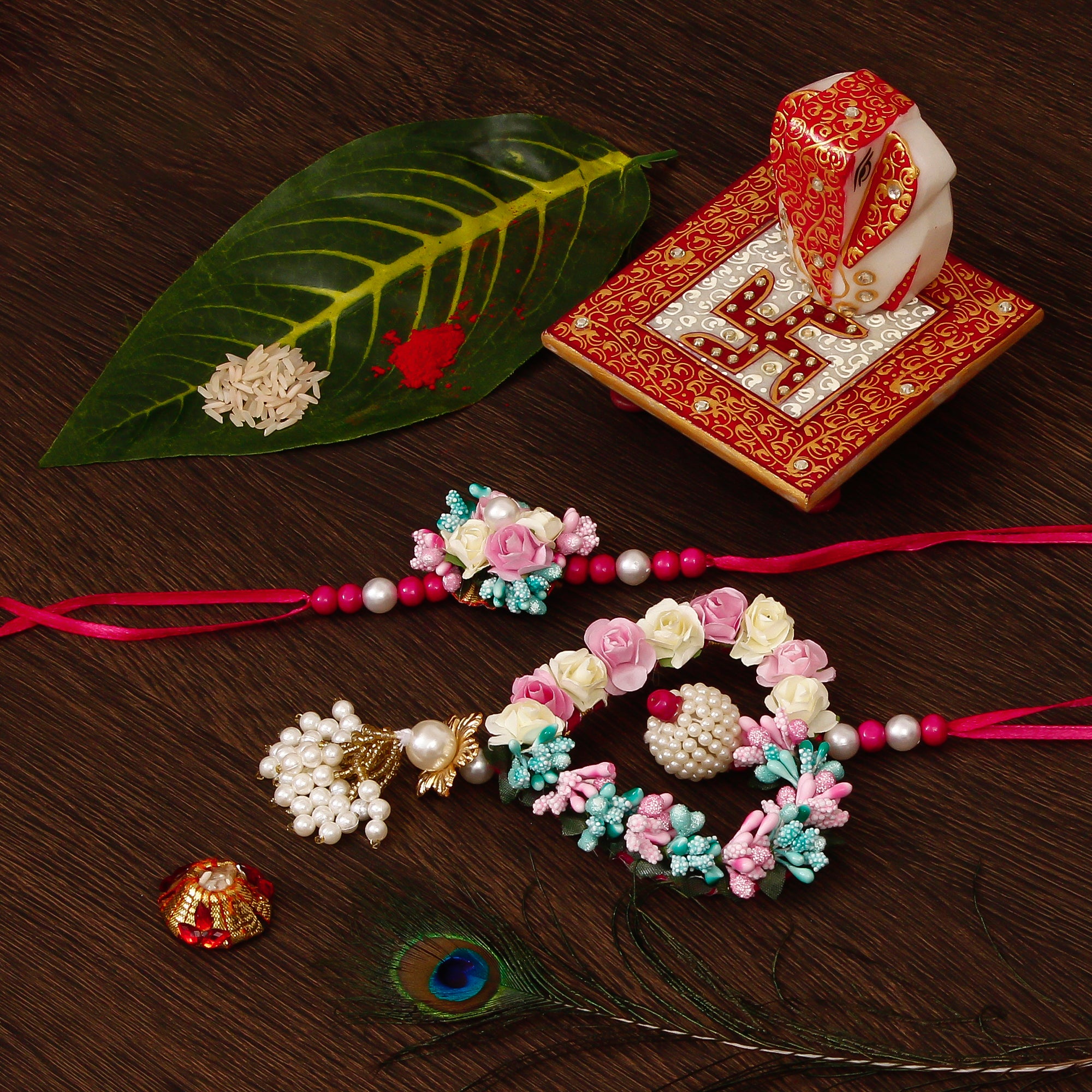 Floral and Heart Shape Bhaiya Bhabhi Rakhi with Ridhi Sidhi Marble chowki and Roli Tikka Matki