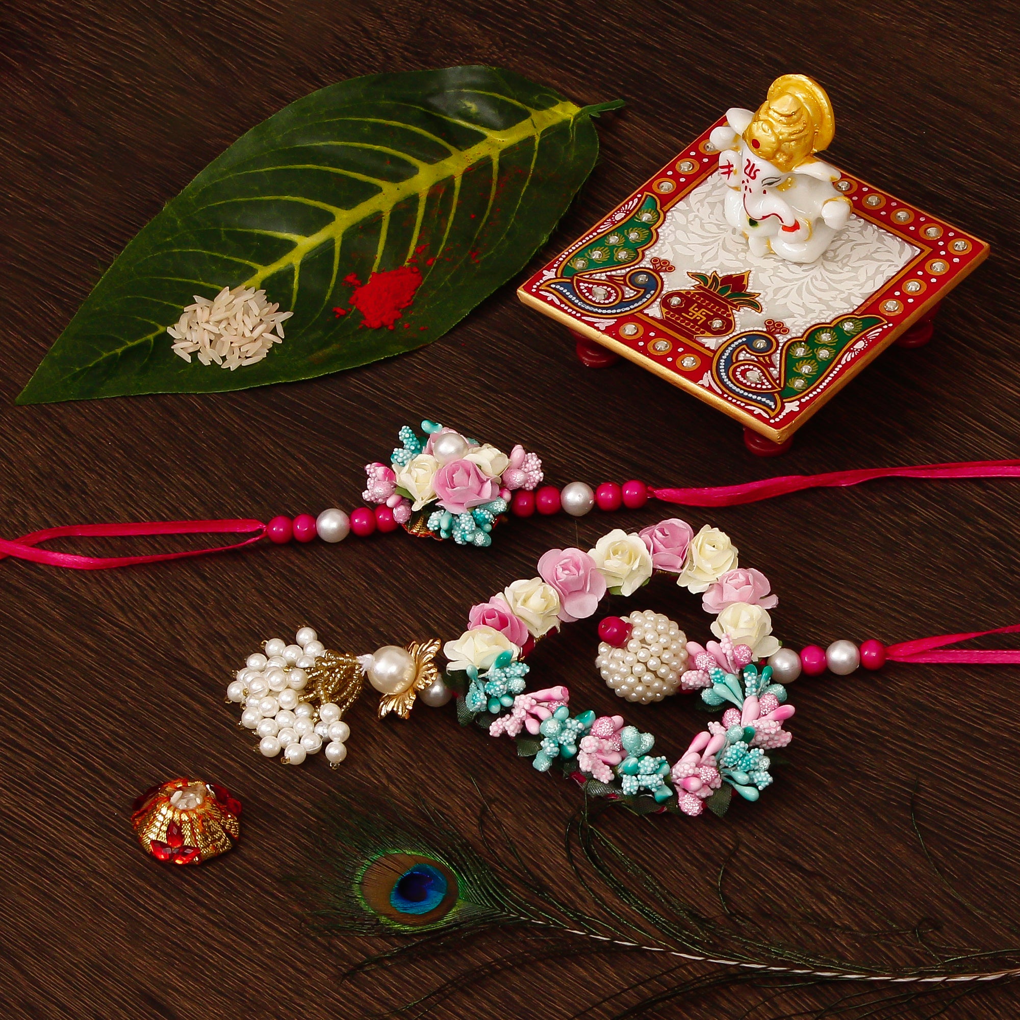 Floral and Heart Shape Bhaiya Bhabhi Rakhi with Lord Ganesha Marble Chowki and Roli Tikka Matki