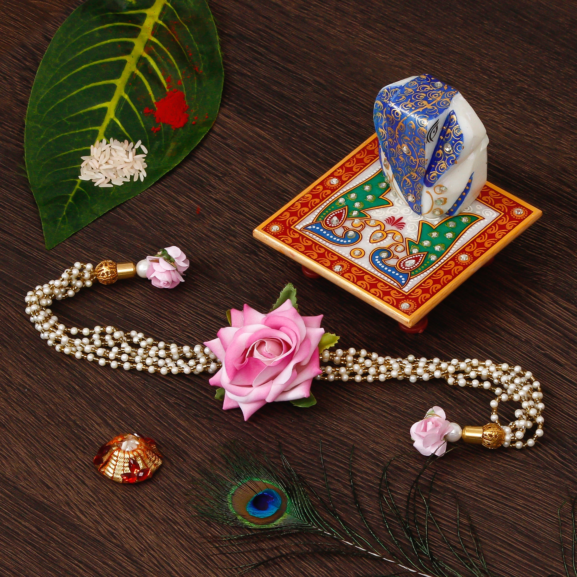 Floral Rakhi for Bhabhi with Lord Ganesha on Marble Chowki and Roli Tikka Matki