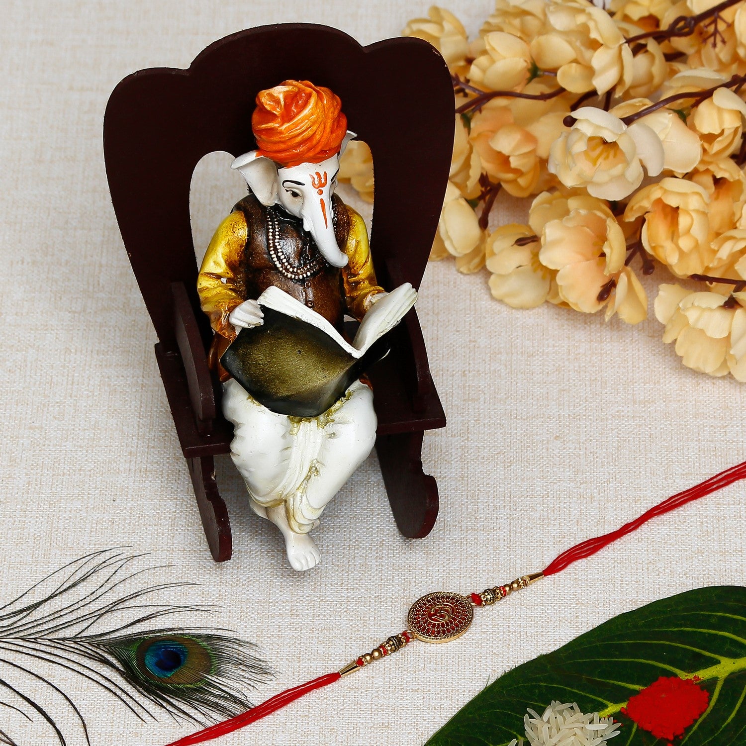 Designer Om Rakhi with Lord Ganesha reading Book on Wooden Chair and Roli Chawal Pack