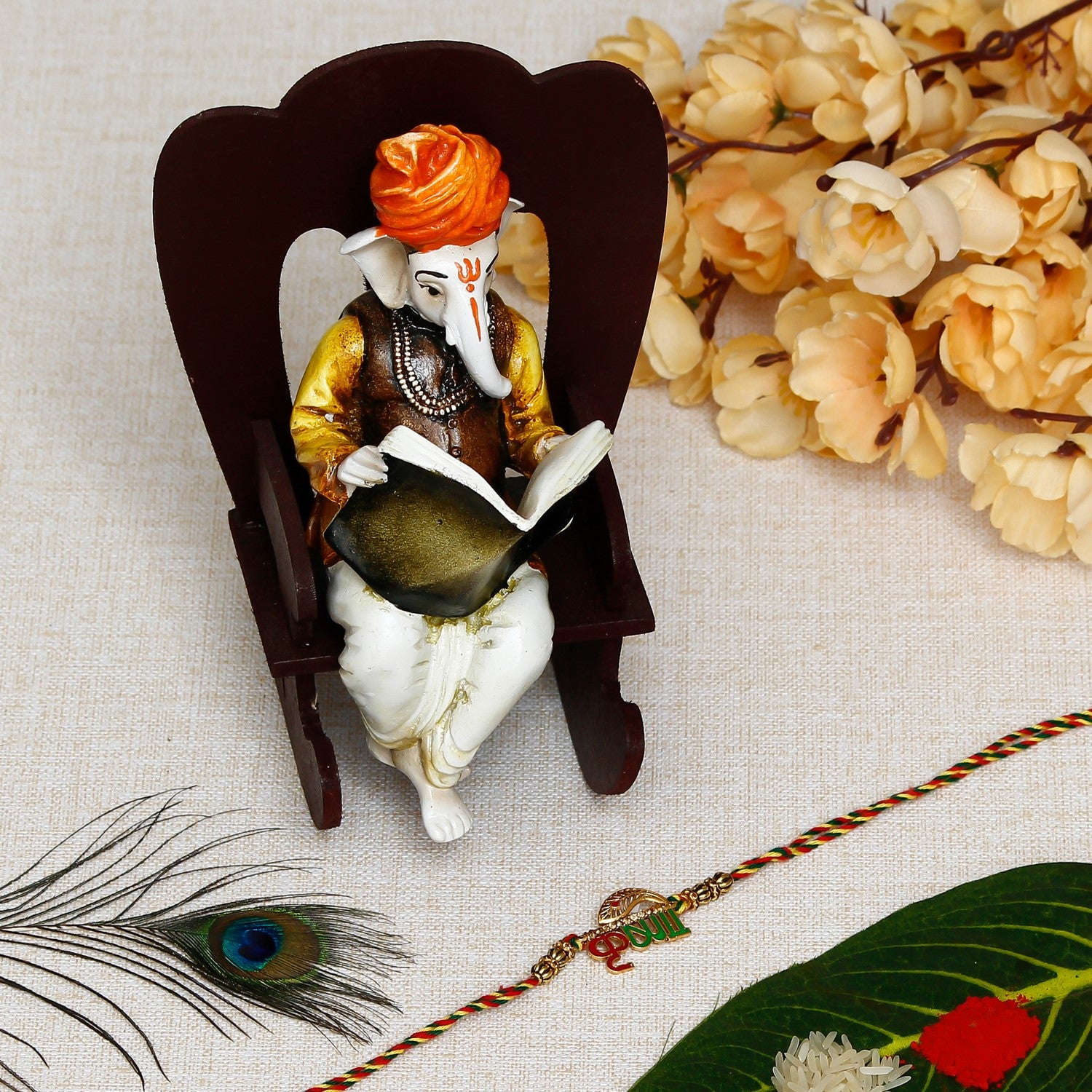 Designer Krishna Rakhi with Lord Ganesha reading Book on Wooden Chair and Roli Chawal Pack