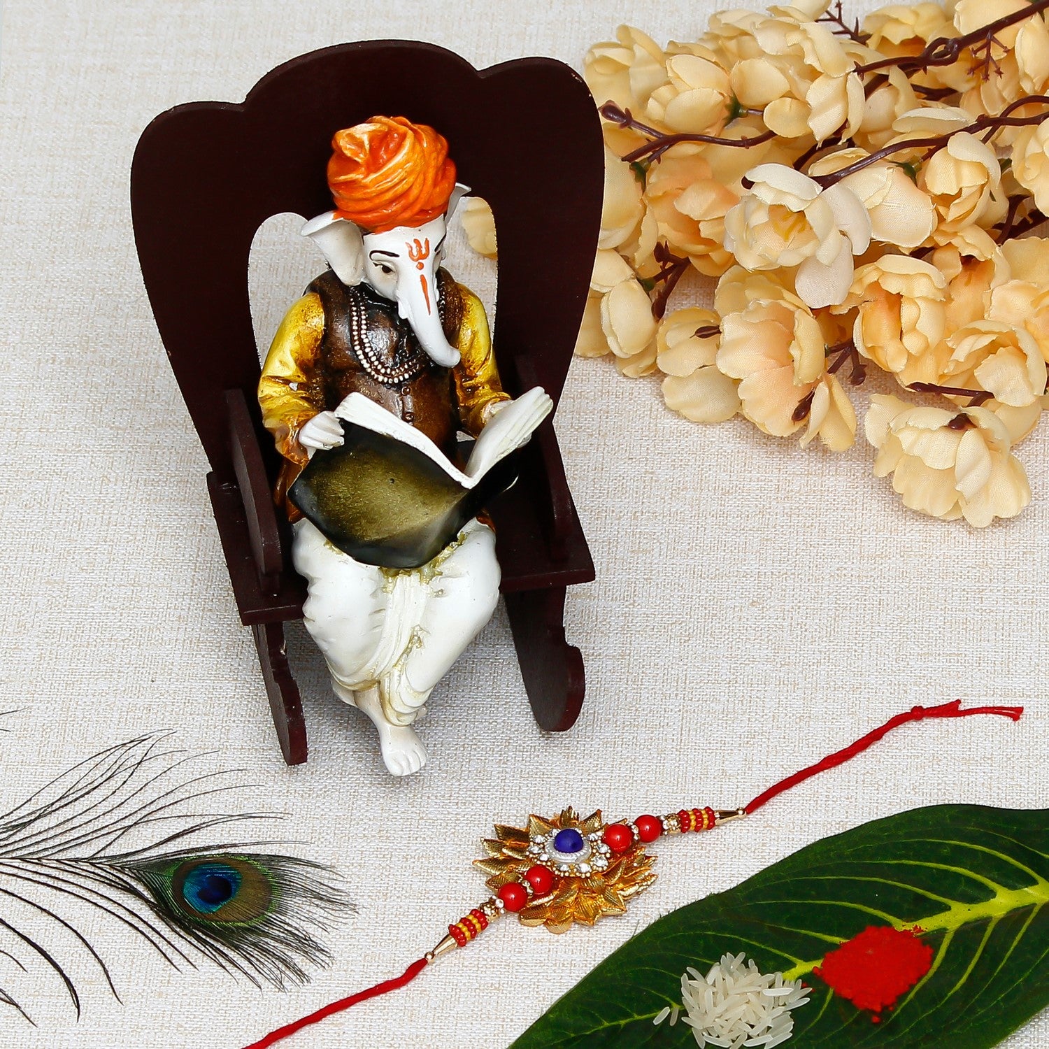 Designer Gota Patti Rakhi with Lord Ganesha reading Book on Wooden Chair and Roli Chawal Pack
