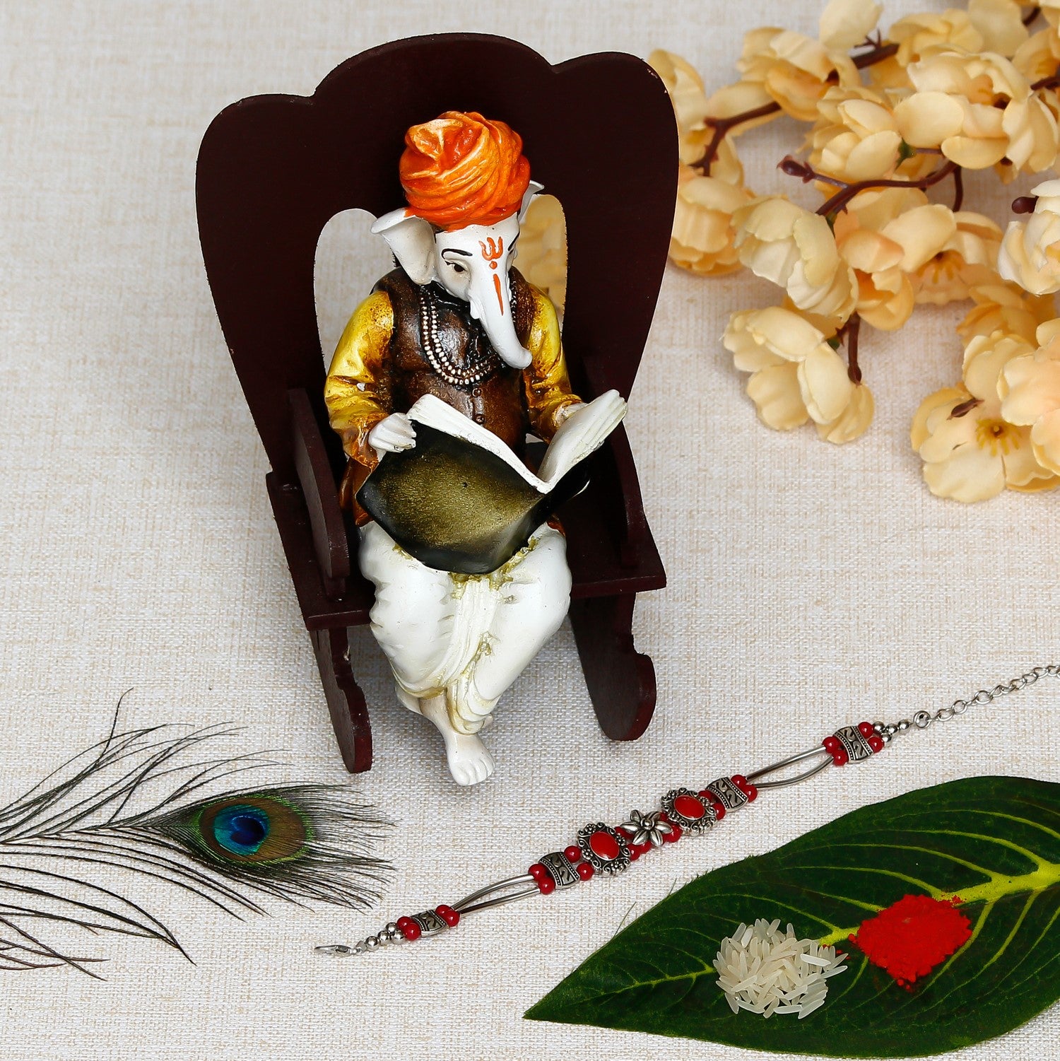 Designer Stone Rakhi with Lord Ganesha reading Book on Wooden Chair and Roli Chawal Pack