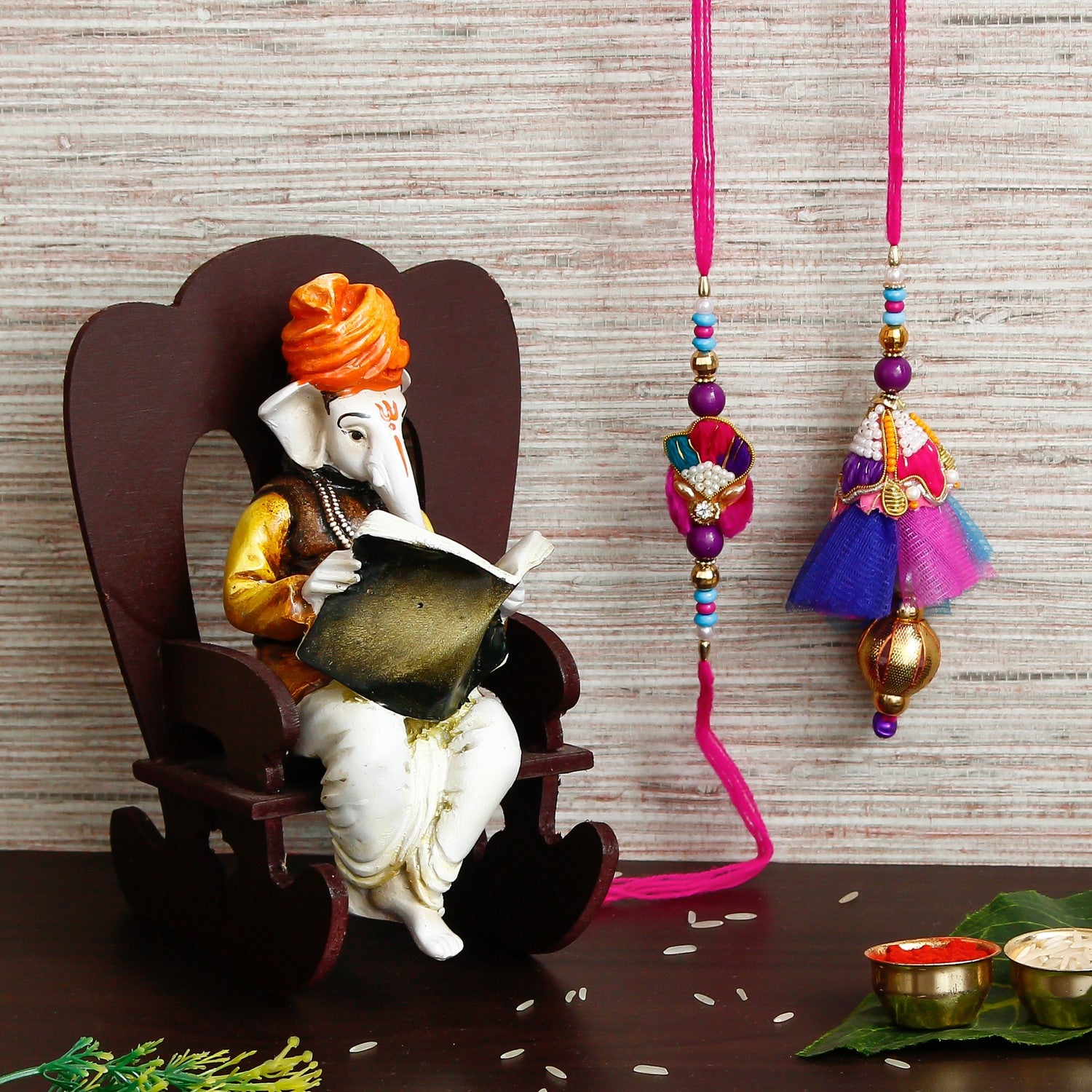 Designer Bhaiya Bhabhi Rakhi with Lord Ganesha reading Book on Wooden Chair and Roli Chawal Pack