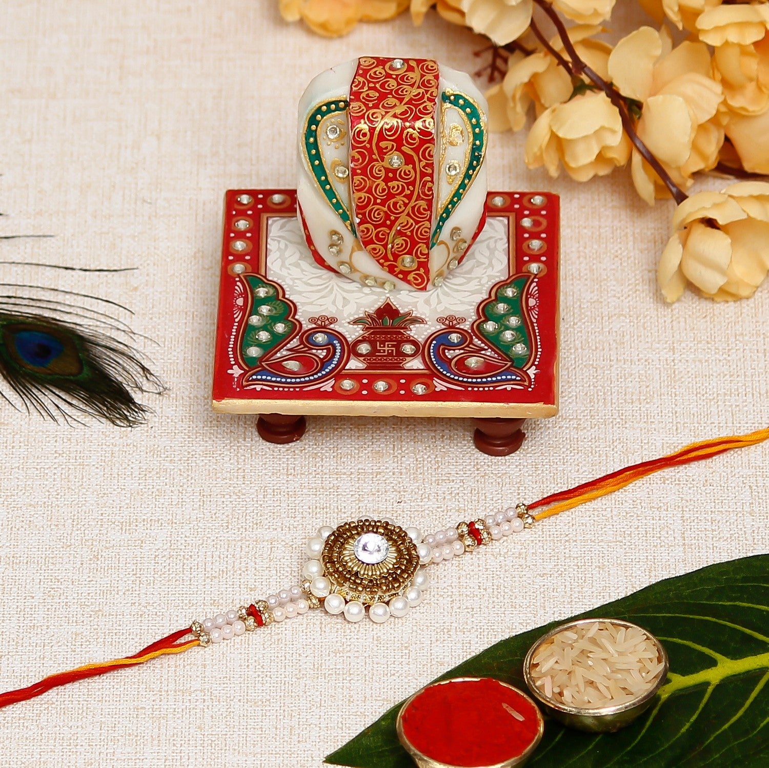 Desginer Stone and Pearl Rakhi with Lord Ganesha on Marble Chowki and Roli Chawal Pack