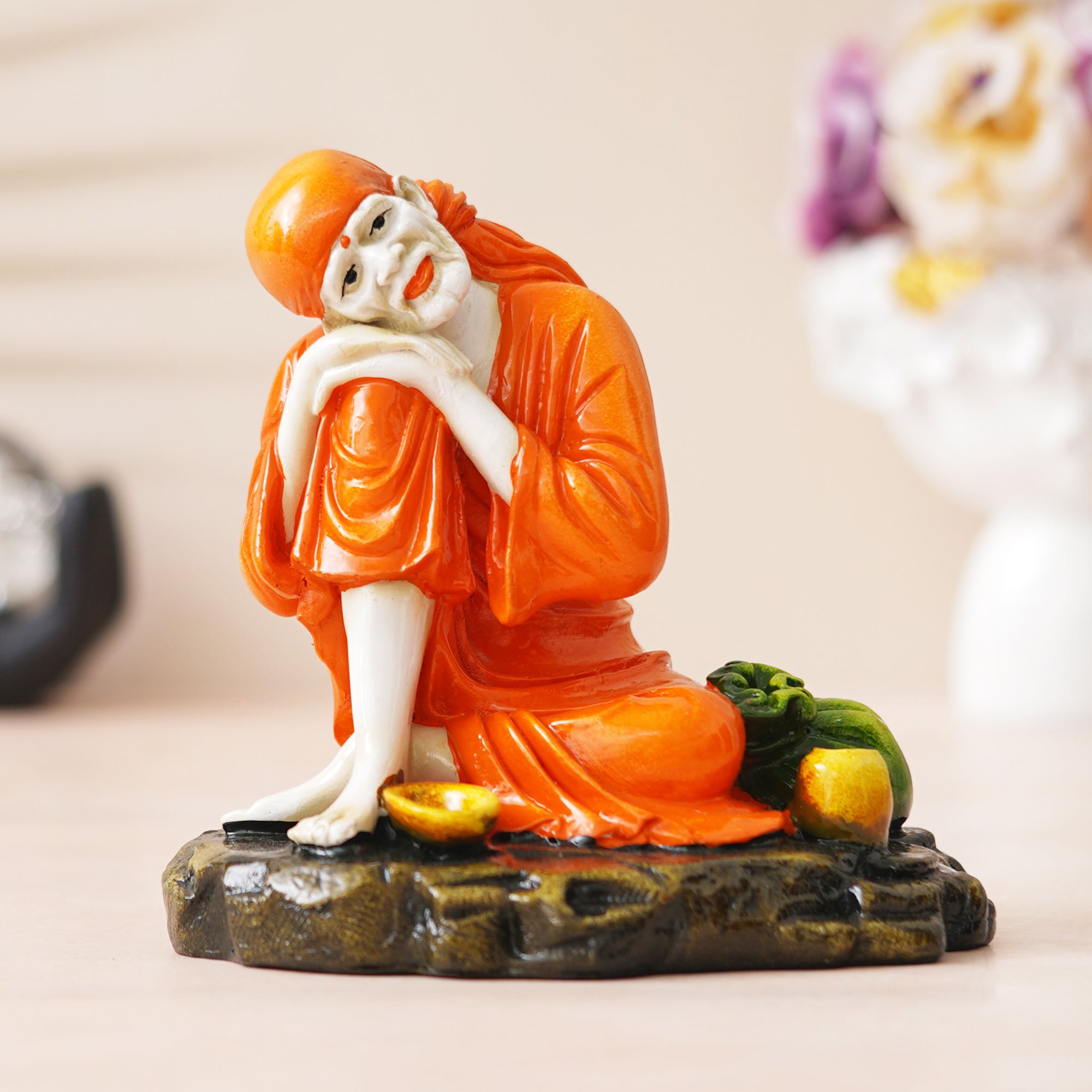 eCraftIndia Orange Polyresin Handcrafted Sai Baba Idol Resting on his Knee