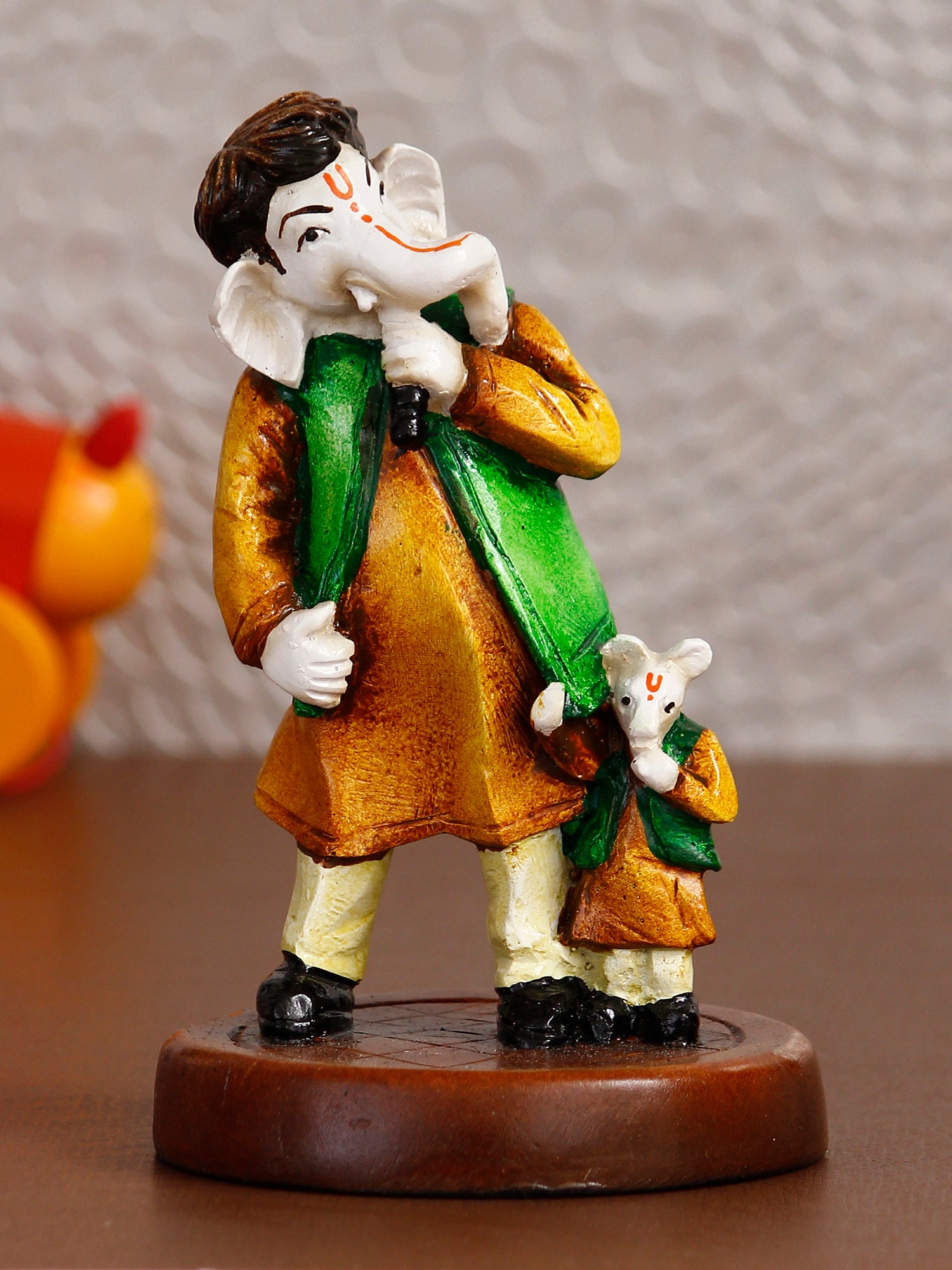 Orange and Green Handcrafted Polyresin Lord Ganesha Idol Singing with Mushak