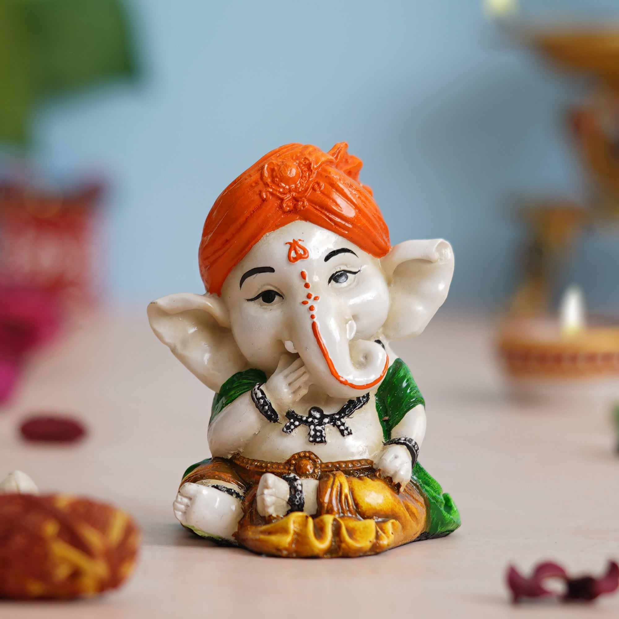 eCraftIndia Orange Polyresin Handcrafted Eating Lord Ganesha Idol while Sitting