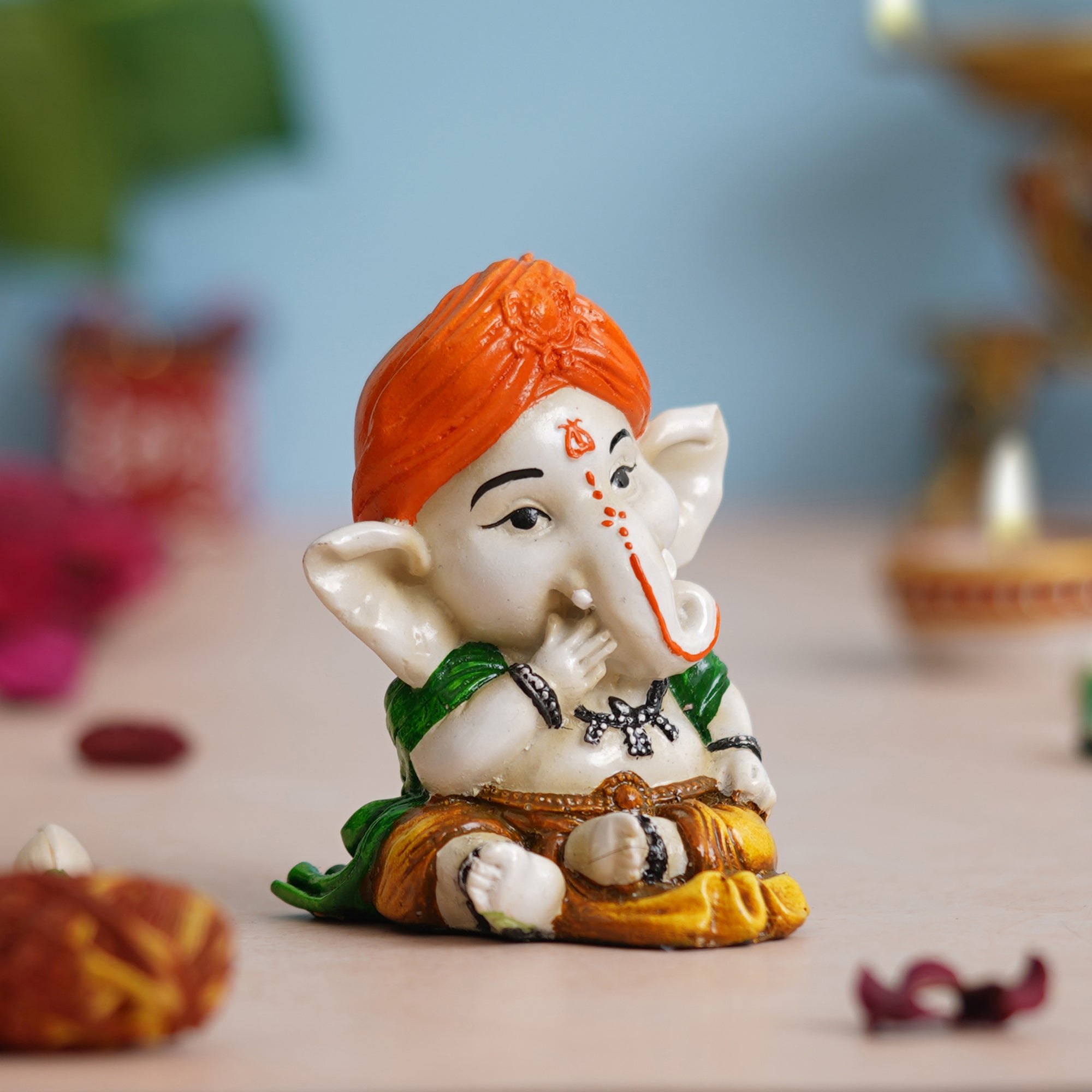 eCraftIndia Orange Polyresin Handcrafted Eating Lord Ganesha Idol while Sitting 1